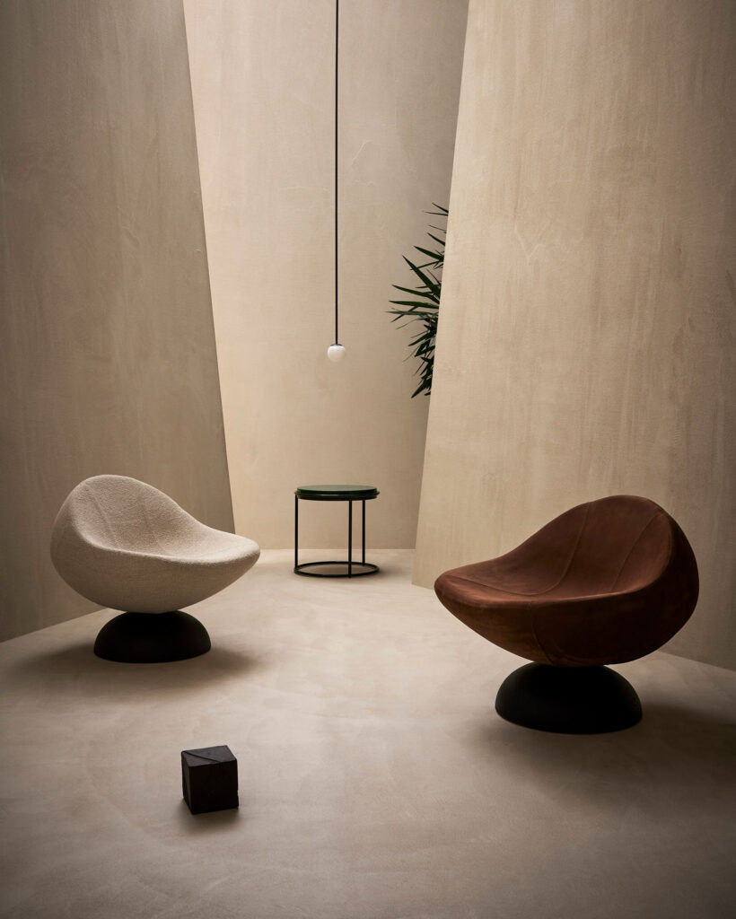 Glove armchairs in rust and white in room with concrete walls