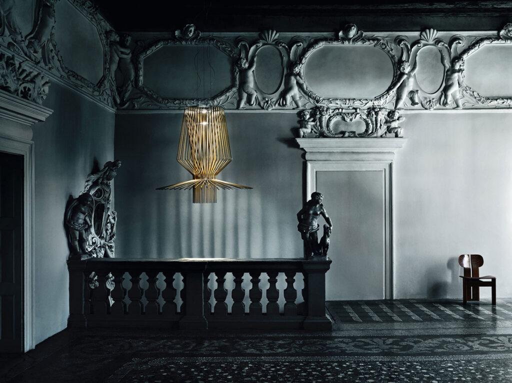 Allegro light with copper finish in museum-like space with ornate walls and statues