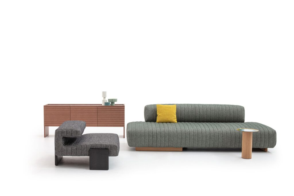 Rows furniture with console in medium wood, gray chair, and green sofa