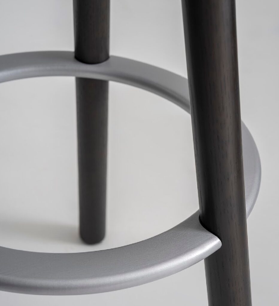 Detail of footrest in chrome with black wooden legs