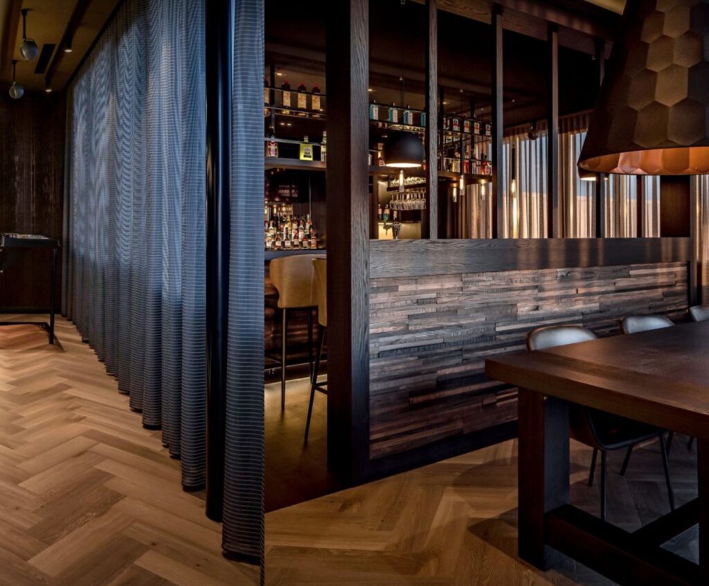 Wood paneling half-wall feature in deluxe bar in penthouse, many different woods with theme of dark wood