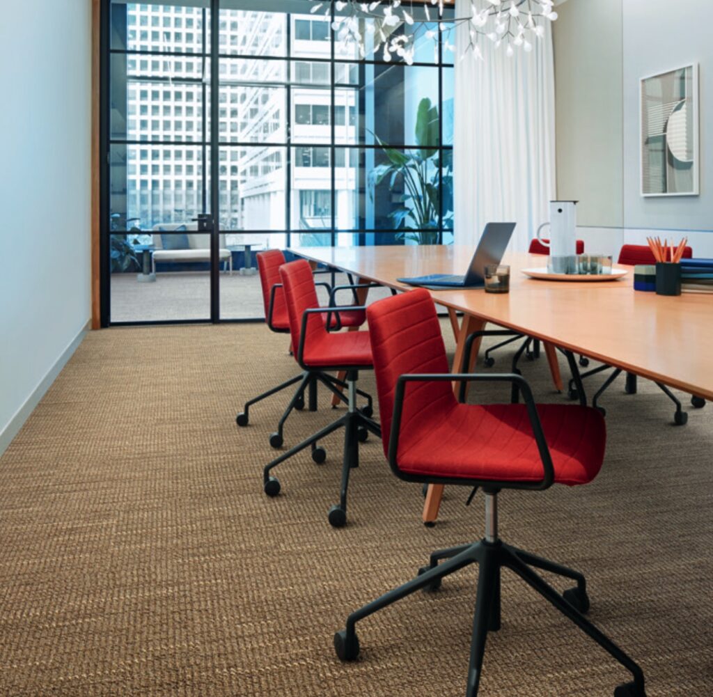 Gradience in tan color on floor of conference room with red task chairs