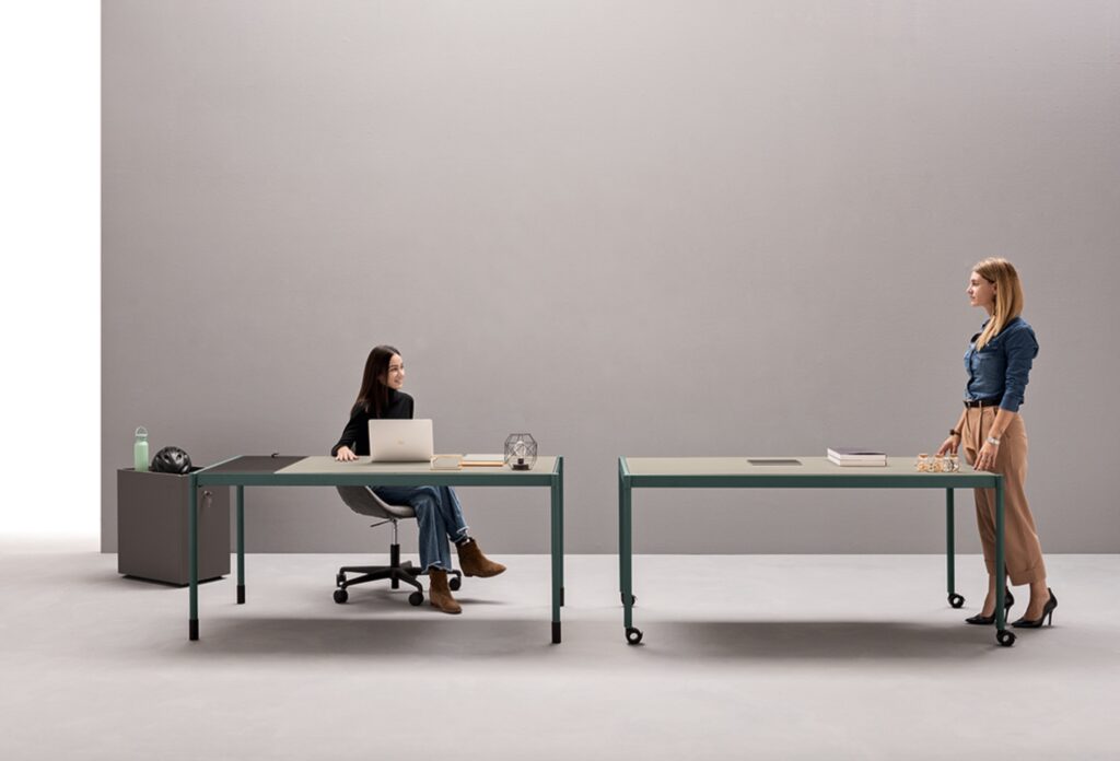 Fluido side by side desks with woman sitting and woman standing