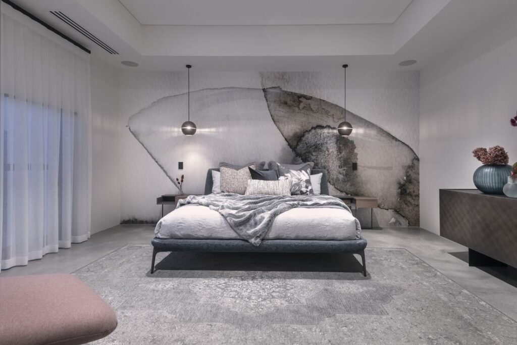 Bedroom scene with two 
Saturn pendant lamps on either side of bed in mostly white room