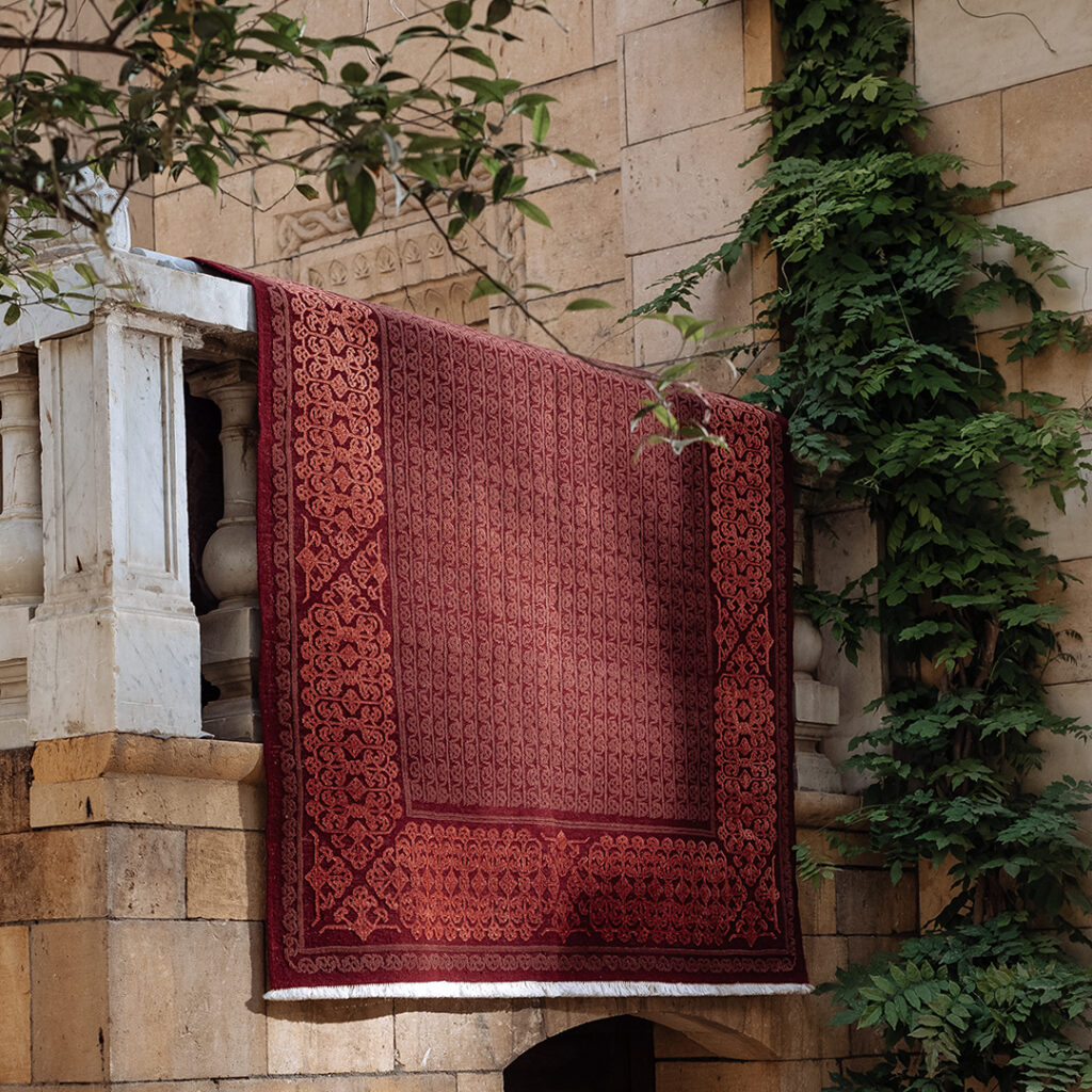 Kiliim red Arabesque rug draped over balcony