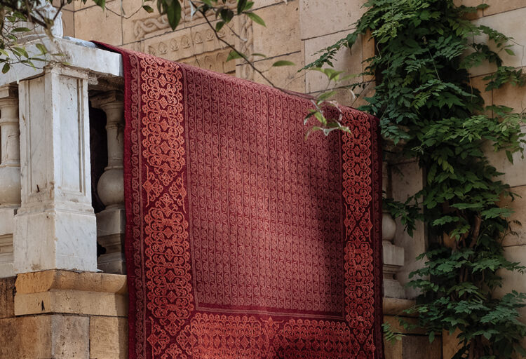 Kiliim red arabesque rug draped on banister