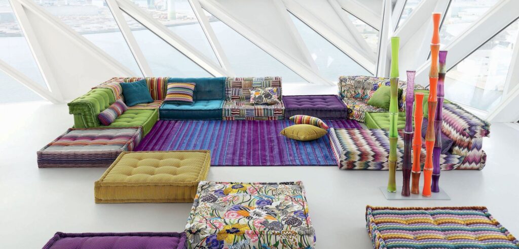 Missoni composition atop striped blue and purple rug in room with slanted glass ceiling