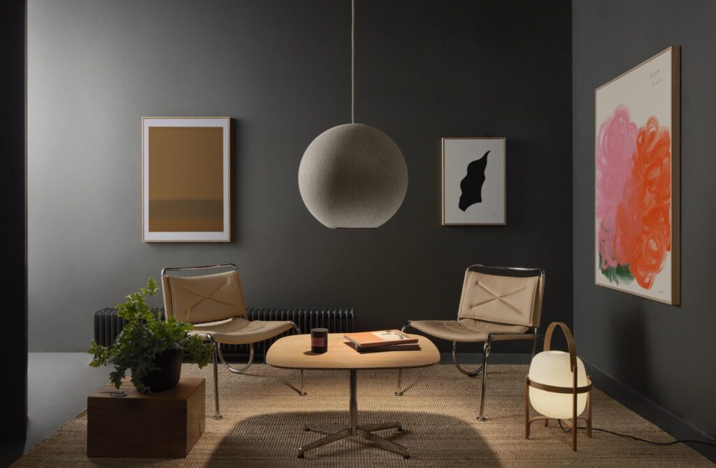 Wall of Art room with three paintings and acoustical pendant