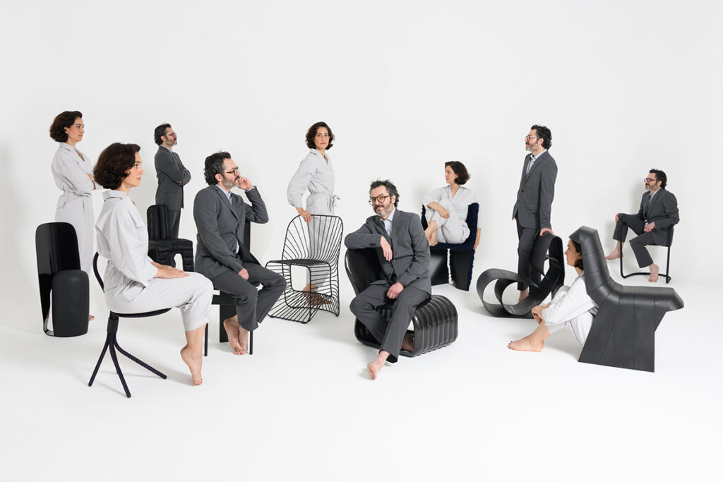 All ten wild chairs with the designers and designers' clones seated in them 