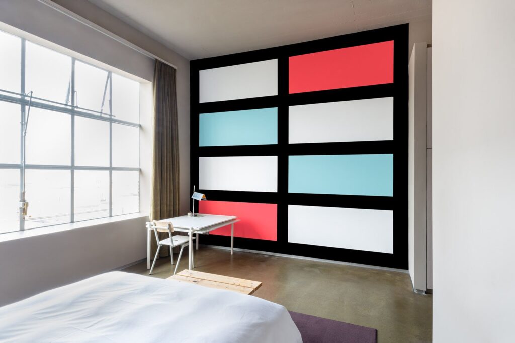 Wall in bedroom painted in white, blue, red squares on black background