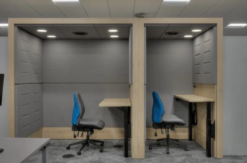 Two individual workspace sheltered areas with standing desks, one with enhanced width