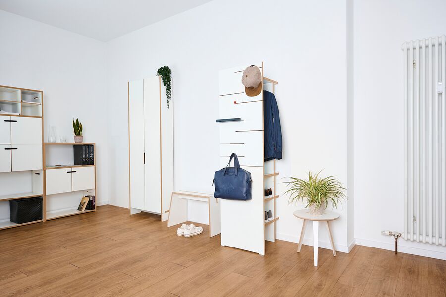 Wardrobe made of white MDF side view showing hanging valise and cap