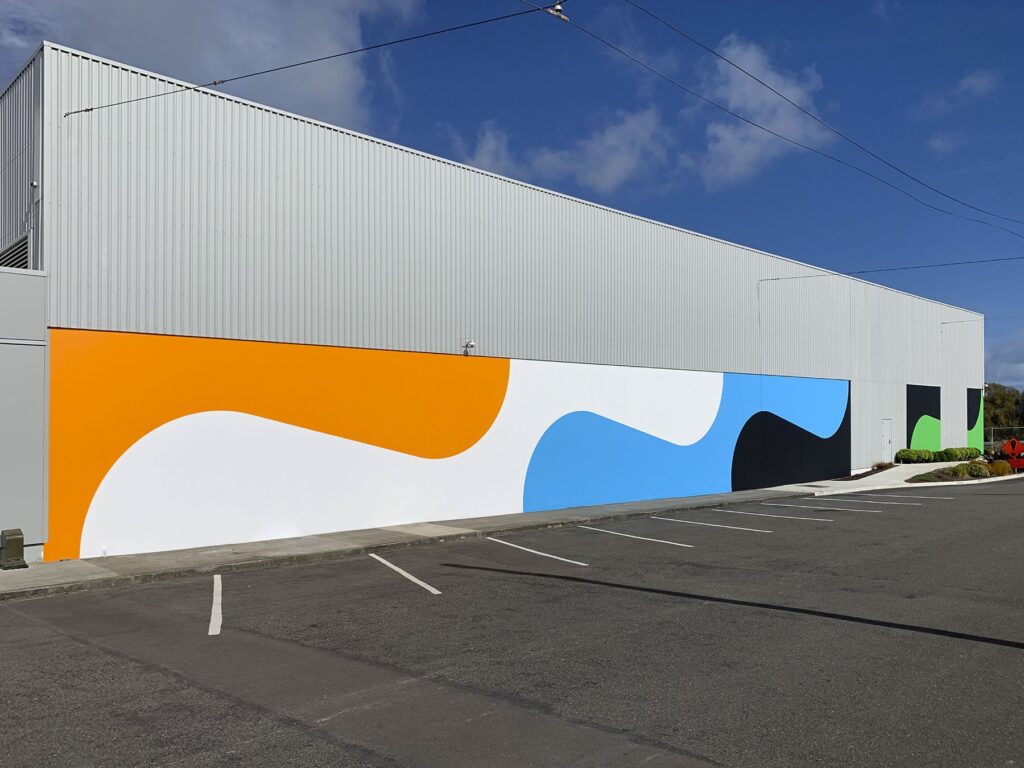 Outdoor mural with curvy shapes in orange, white, blue, black