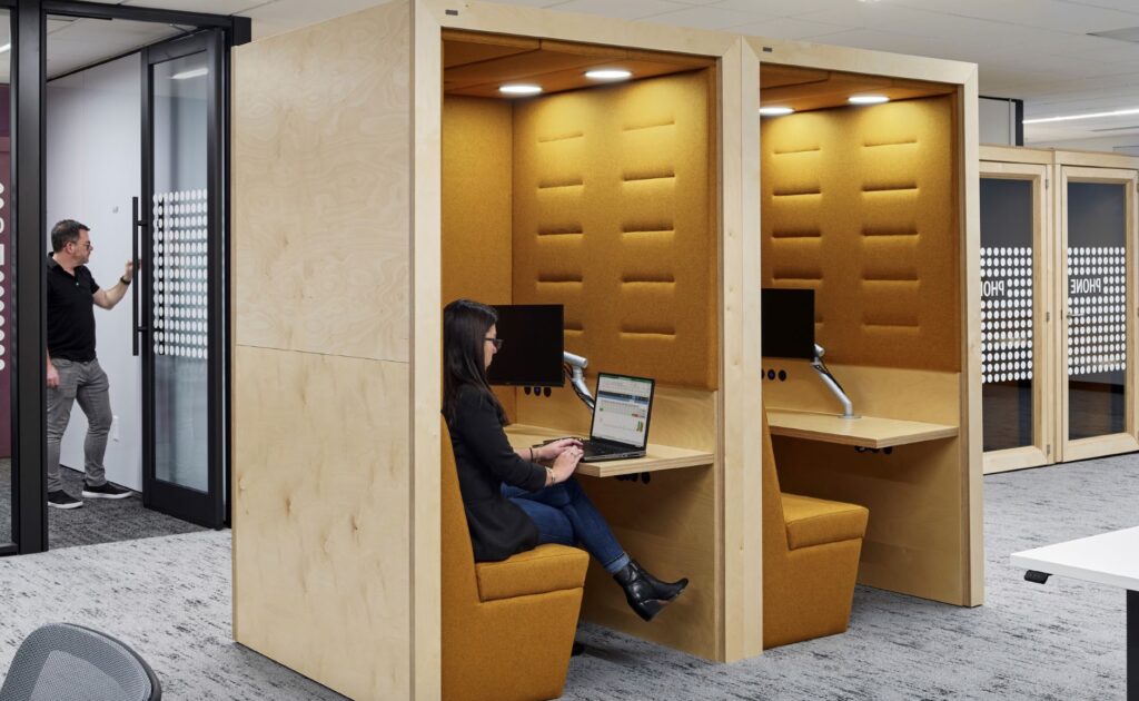 Portal, built-in seating and desk with monitor and woman working