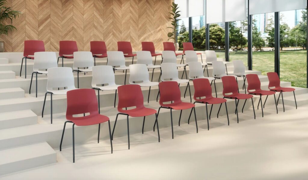 Imme chairs in rows of coral and white in auditorium