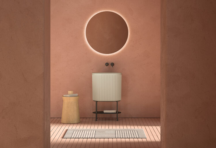 Inbani washbasin in room with salmon-colored walls and round mirror