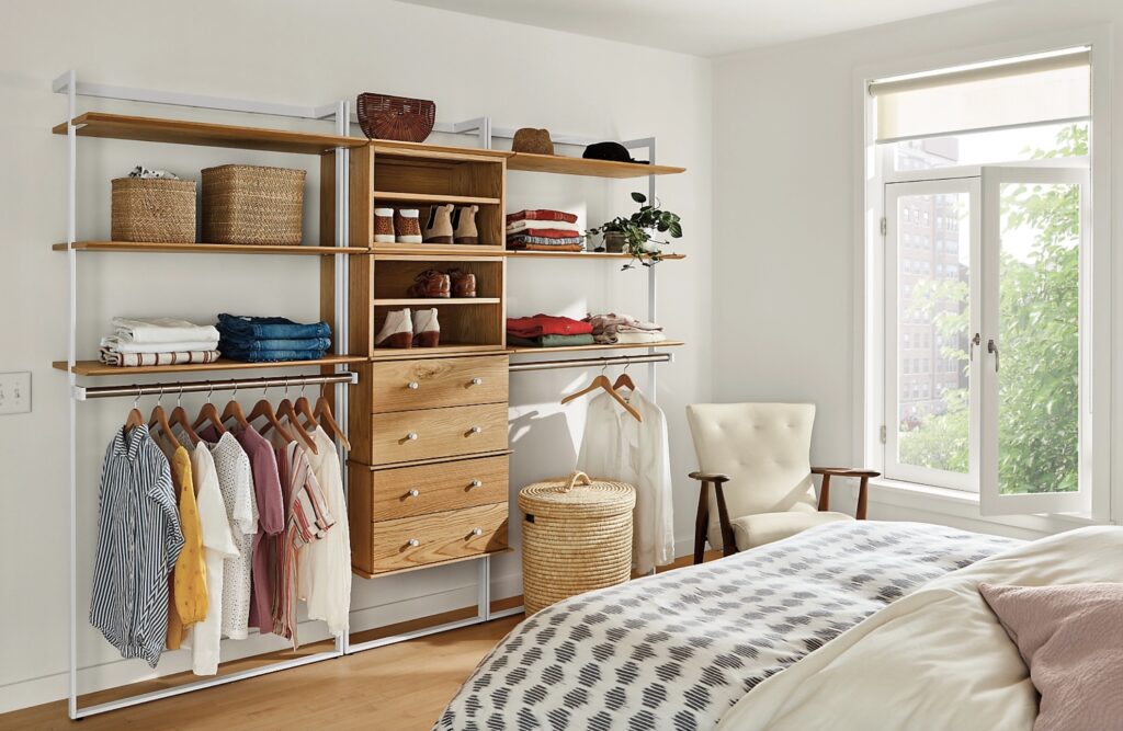 Beam bookcase with open shelves and drawers with clothing in bedroom