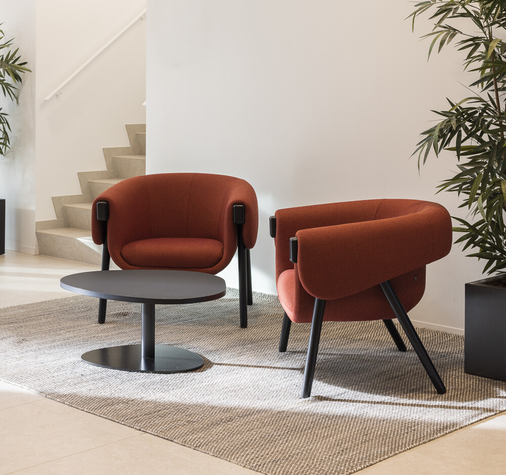 Two chairs in orange upholstery on black wood legs in sitting room