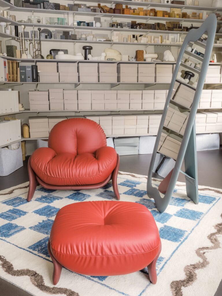 Squash in red with red ottoman, green mirror, and patchwork rug