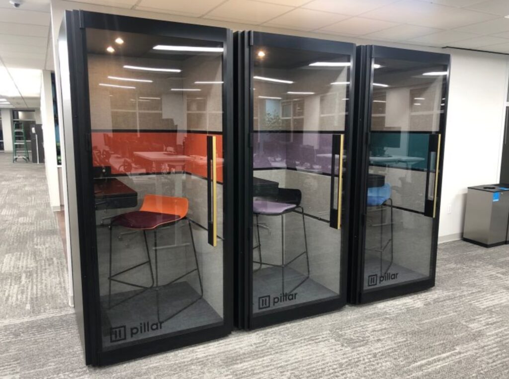 Three side by side phone booths in office with different interior colors