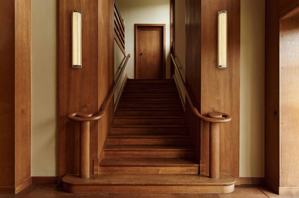 SuperWire sconces flanking beautiful wooden staircase