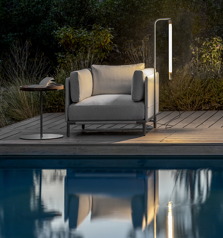 Lounge chair with integrated lamp on poolside deck