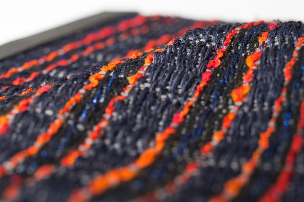 detail of fiery textile: black with thin orange stripes