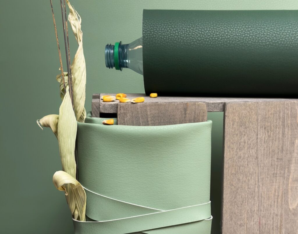 Corn-based fabric backcloth in light and dark green with partial view of wood fence post and corn kernels.