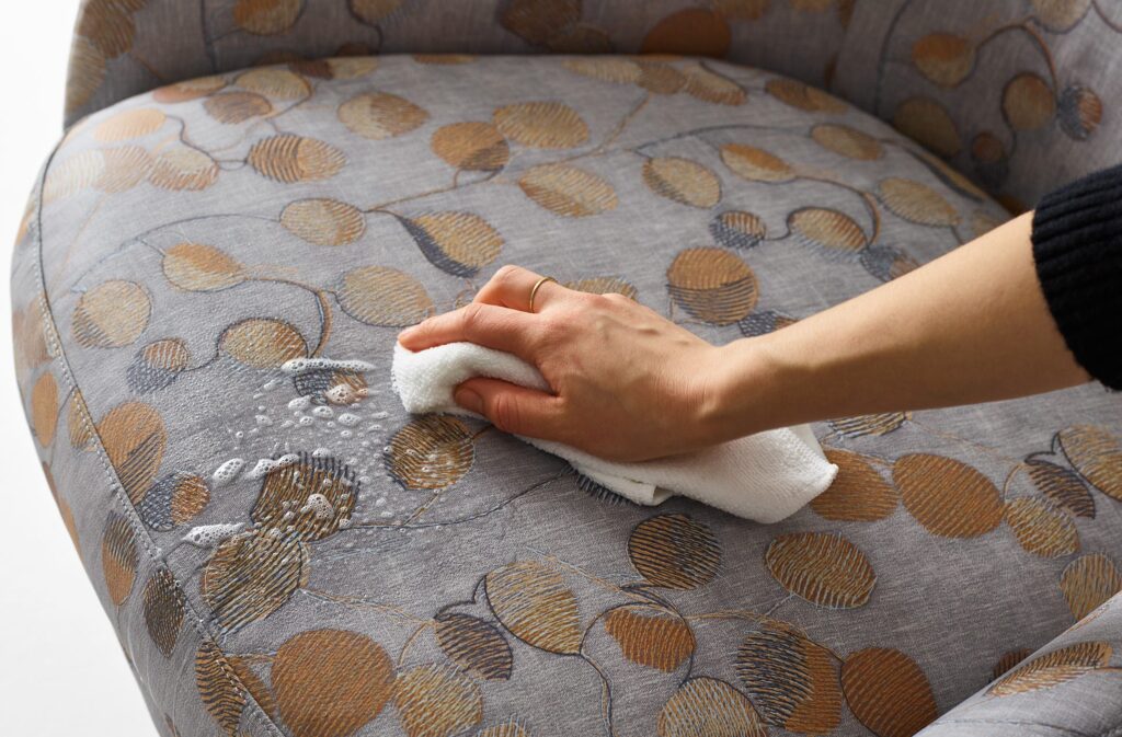 Someone cleaning a chair upholstered in Botanic Print