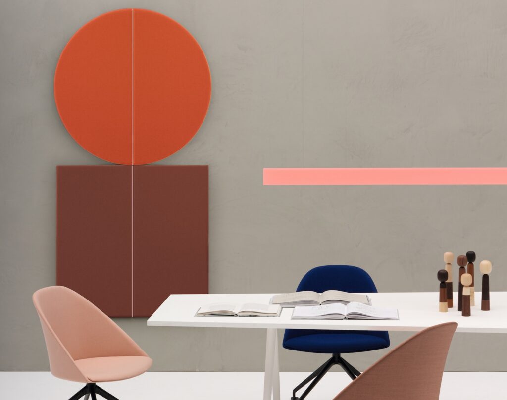 In red with maroon panel in square near work table with chairs