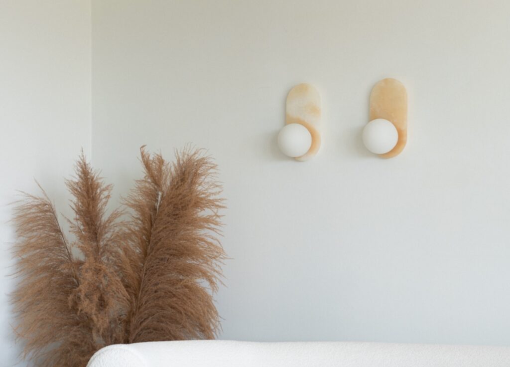 Two sconces in creamy shade on white wall