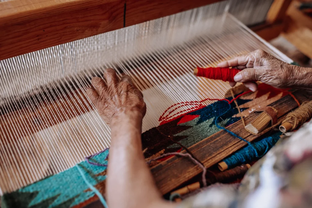 An artisan at work weaving on a traditional loom