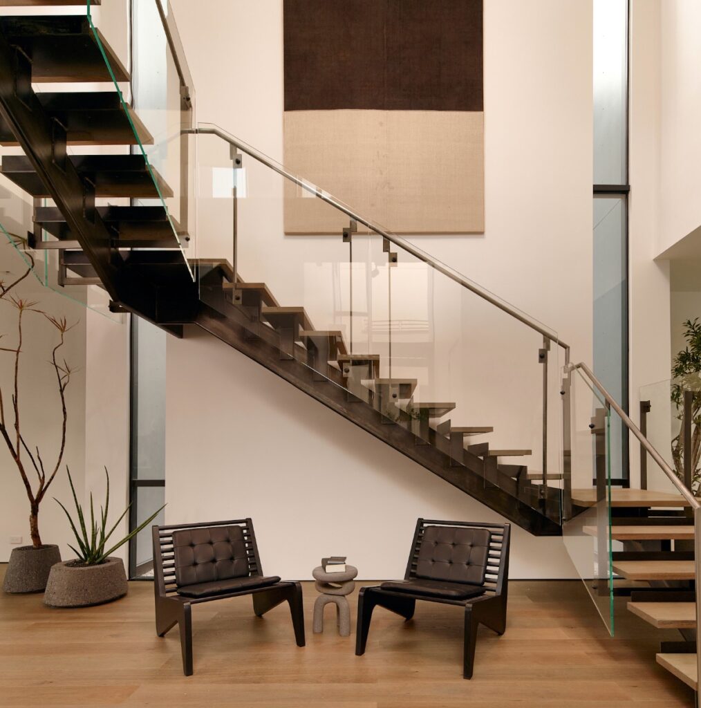 Stairs with glass panel sides and Ala chairs in open atrium