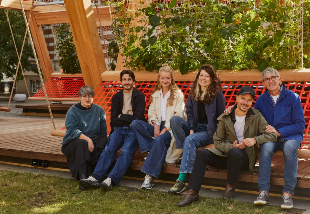 Vert team seated beneath climbing greenery