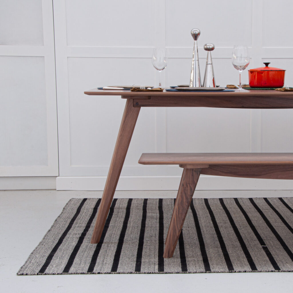 Partial view of Walnut dining table with bench