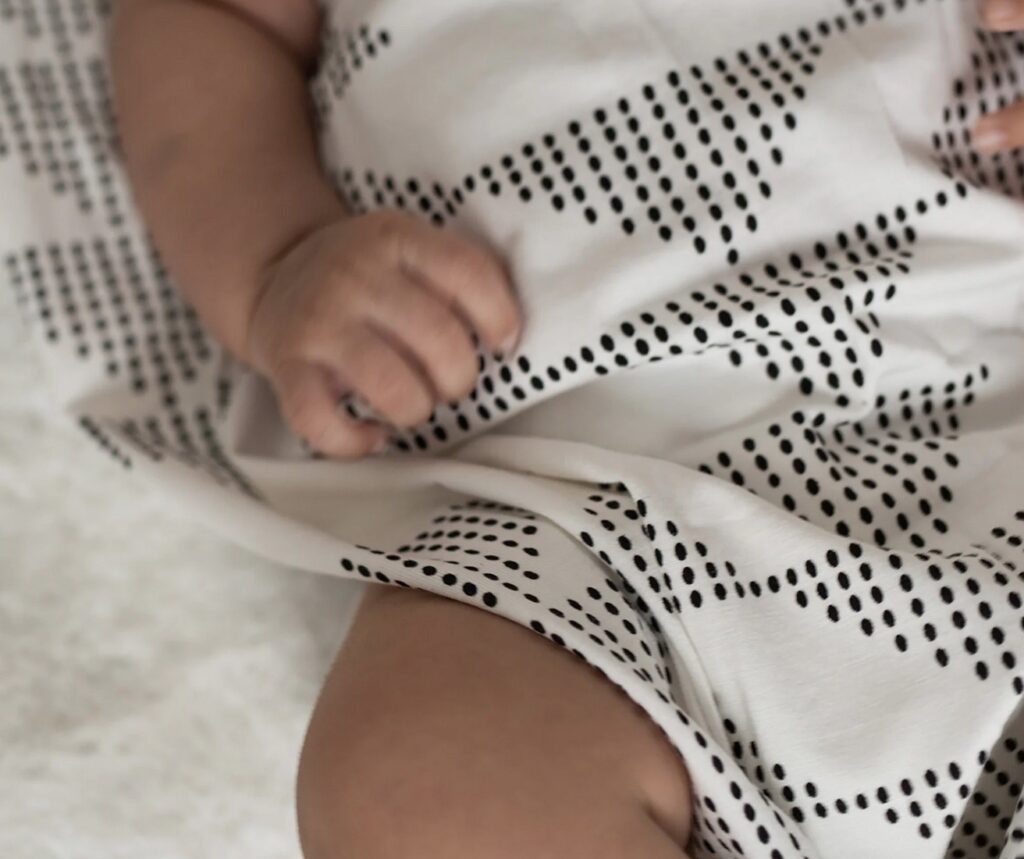 White and black swaddling cloth on baby