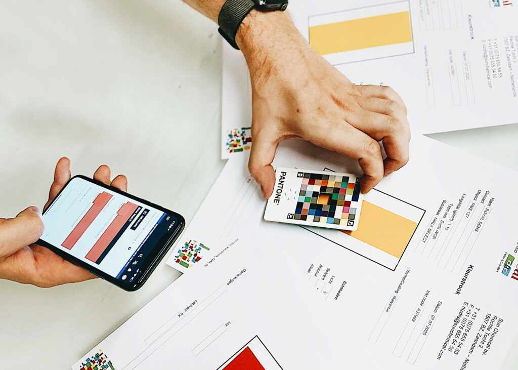 hand with Pantone color card; photo by quinten braem via unsplash